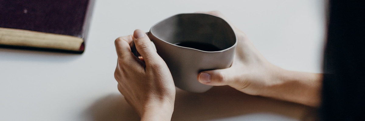 mains autour d'une tasse