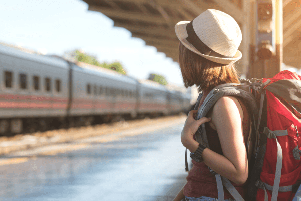mobilité 3 jeune femme attendant un train avec un sac à dos