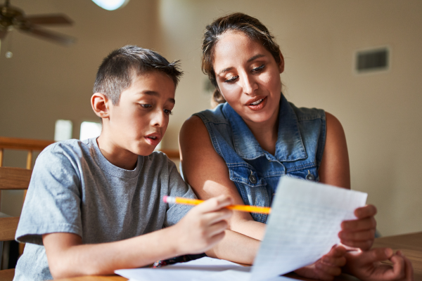 assistante de vie aux famille qui aide un enfant à faire ses devoirs