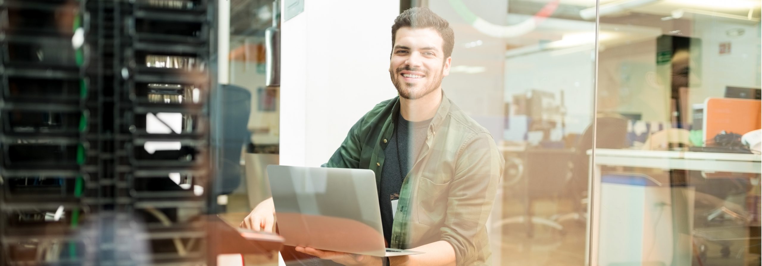 jeune souriant sur un ordinateur portable