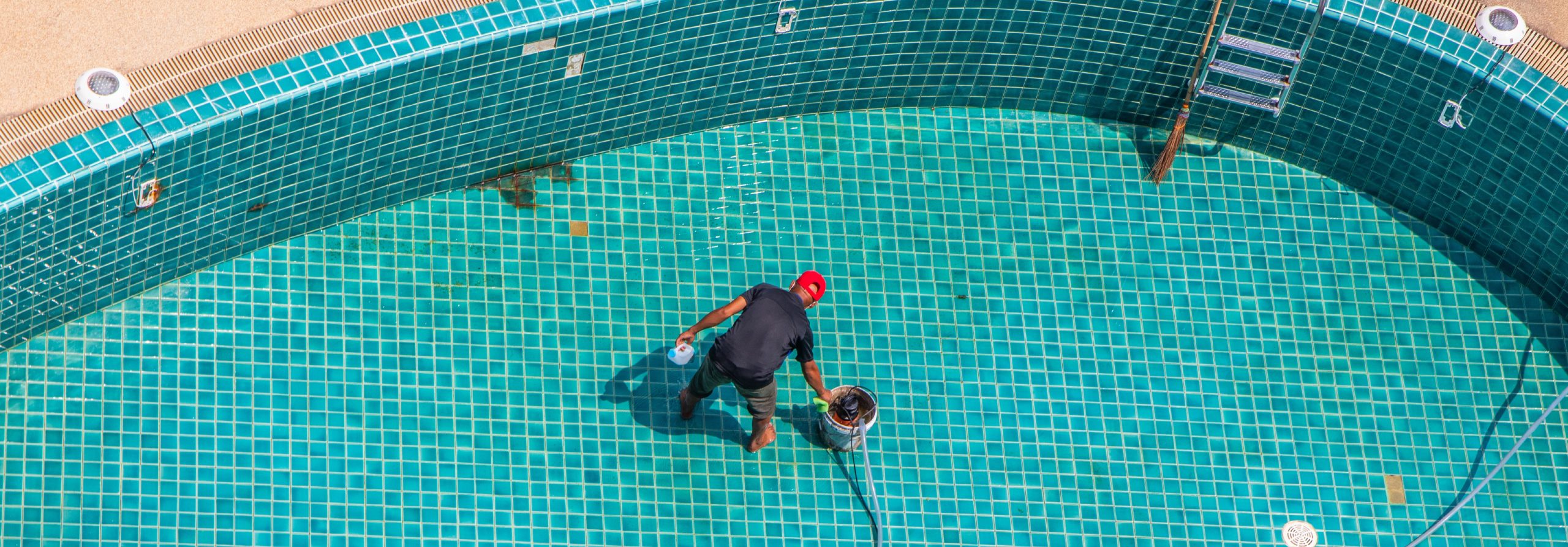 Piscinier en opération de nettoyage une piscine vidée