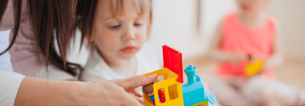 accompagnant éducatif donnant un jouet à un enfant