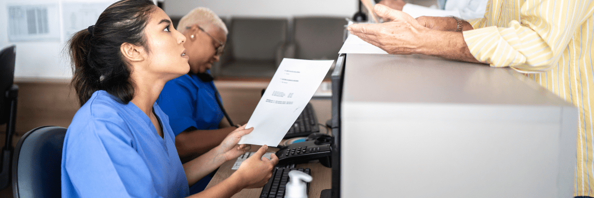 secrétaire médicale à l'accueil avec un patient